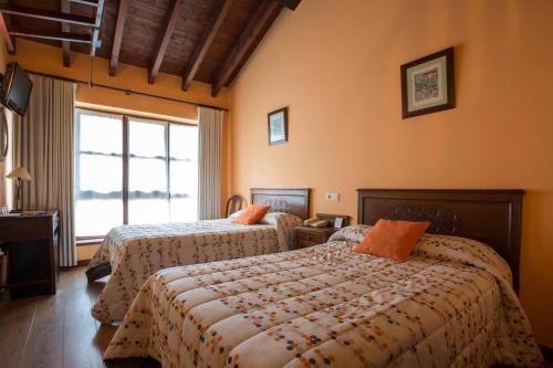 - une chambre avec 2 lits et une fenêtre dans l'établissement Hotel El Carmen, à Ribadesella