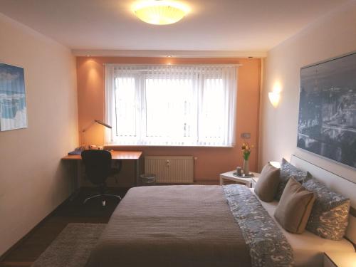 Un dormitorio con una cama y una ventana y un escritorio. en Apartment S - perfect stay, en Leipzig