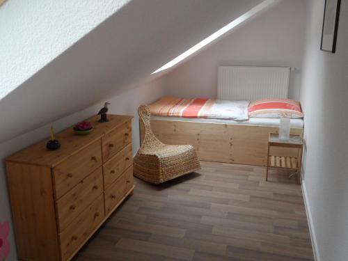 a bedroom with a bed and a dresser in a attic at Ferienwohnung an der Therme in Bad Schandau