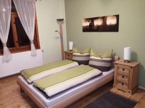 Schlafzimmer mit einem Bett, einem Tisch und einem Fenster in der Unterkunft Ferienhaus im Kumbachtal in Gräfenthal