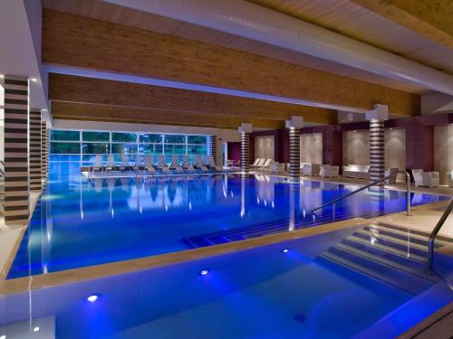 een groot zwembad met blauw water in een hotel bij Hotel Mioni Pezzato in Abano Terme