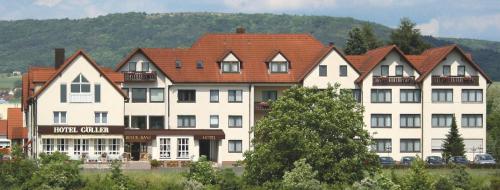 a large white building with a red roof at Hotel Göller in Hirschaid