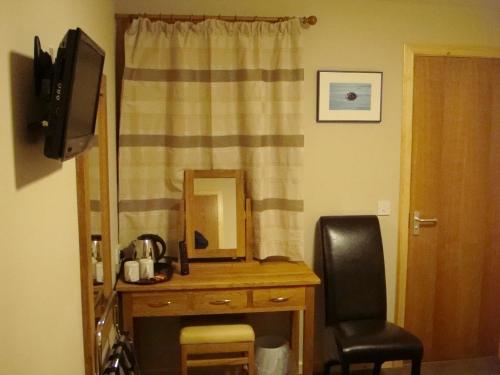 a room with a desk with a mirror and a chair at Seaview John O Groats Hotel in John O Groats