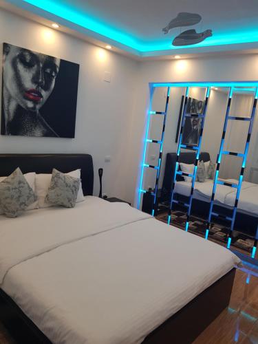 una camera da letto con un grande letto con illuminazione blu di Mirrors Old Town Central a Braşov