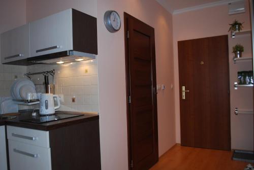 a kitchen with a clock on the wall next to a door at Jurincom apartments in Karlovy Vary