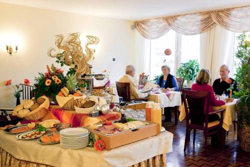 a group of people sitting around a table with food at Hotel Birkenstern in Bad Wildungen