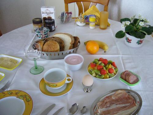 a table with a plate of bread and fruit on it at B&B Korendijk in Zuid-Beijerland