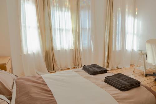 1 dormitorio con 1 cama con 2 almohadas negras en Home In Queen's Park en Londres