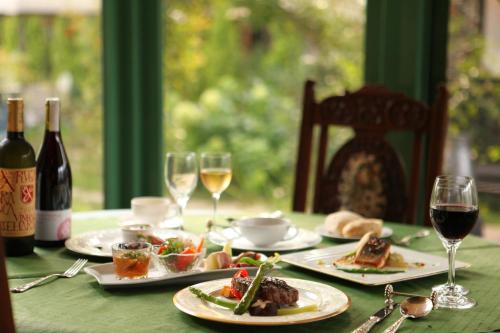 a table with plates of food and glasses of wine at Petit Hotel & Restaurant Old Age in Hokuto