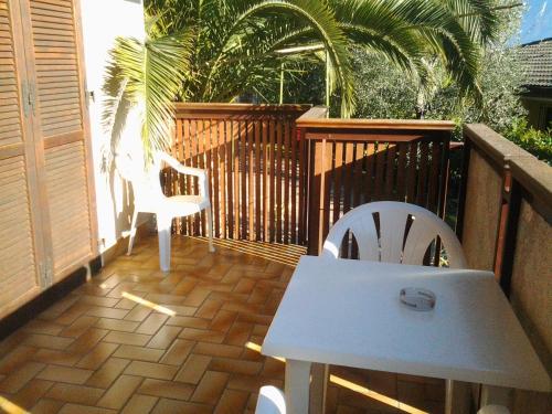a patio with a white table and chairs on a balcony at Residence Miravalle in Limone sul Garda