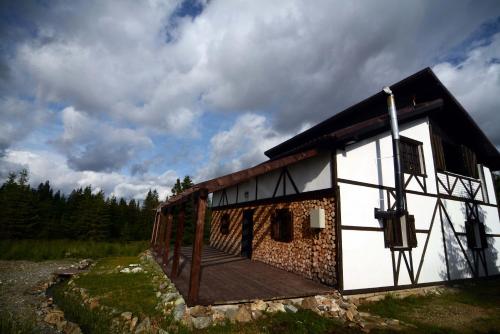 uma casa com um deque ao lado dela em Cabanele Pași Liberi em Tau Bistra
