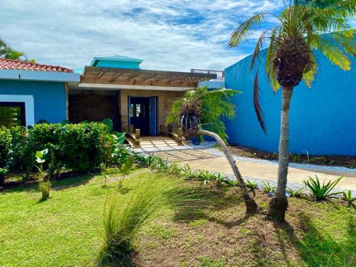 a blue house with palm trees in front of it at Blue Horizon Boutique Resort in Vieques