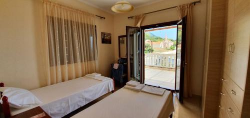 a bedroom with two beds and a balcony at Villa Panorama in Lourdata