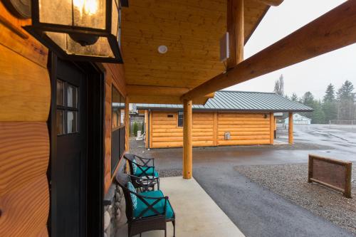 a porch of a log cabin with two green benches at Woodland Inns in Forks