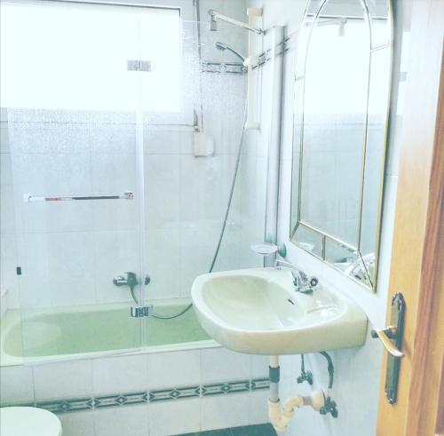 a white bathroom with a sink and a shower at Txoko Maitea Pentsioa in Urnieta