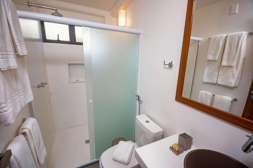 a bathroom with a shower and a toilet and a mirror at Aldeia do Mar Sensorial Hotel in Itacaré