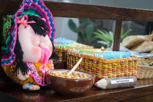 a table with a bowl of peanuts and a doll at Posada San Blas in Cusco