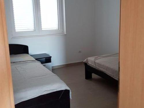 a room with two beds and a window at Contemporary Apartment in Neviđane near Sea in Neviđane