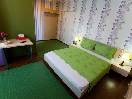 a small bedroom with a bed and a table at Hotel La Gil in Bucharest