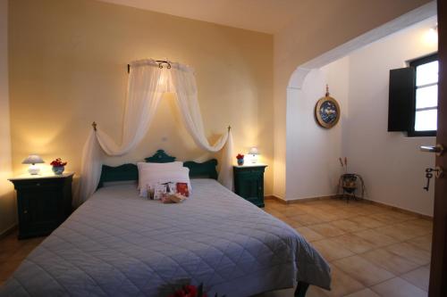 a bedroom with a large bed with a canopy at Vrachia Studios & Apartments in Oia