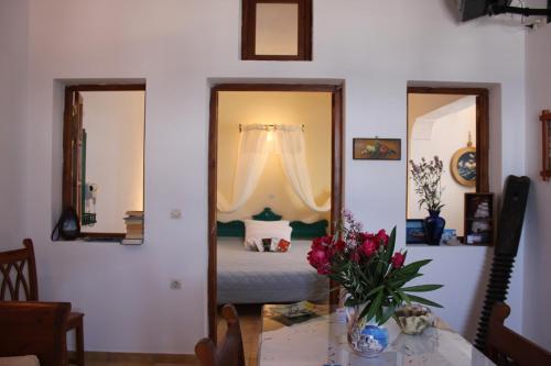 a room with a bed and a table with flowers at Vrachia Studios & Apartments in Oia