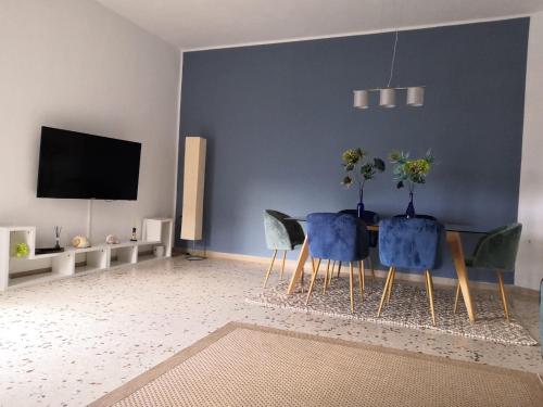 a living room with a table and chairs and a tv at Zibibbo Apartment in Pantelleria