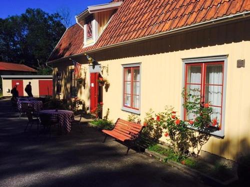 フンボストランドにあるHunnebostrands vandrarhem Gammelgårdenの赤い屋根とベンチのある白い建物