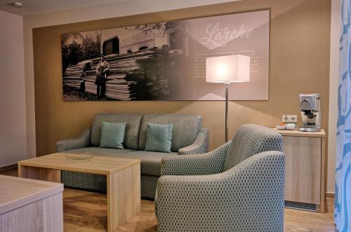 a living room with two chairs and a couch at Hotel Garni Bergblick in Biberach bei Offenburg