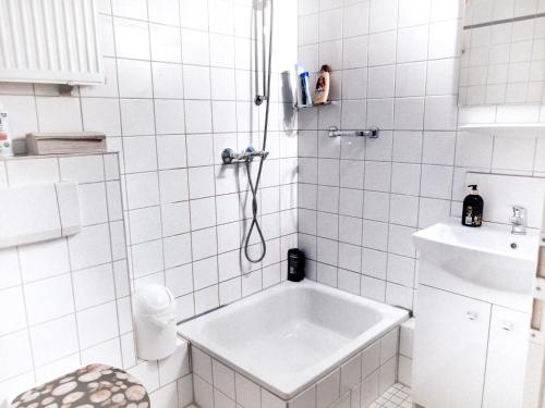 un bagno bianco con vasca e lavandino di A&S Ferienwohnungen Roonstraße a Bonn