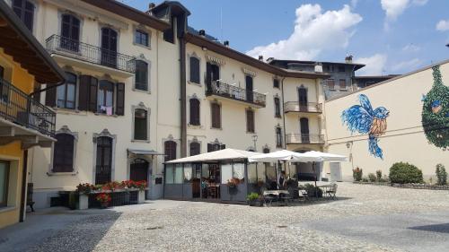 a building with umbrellas and tables in a courtyard at Casa Ramus Valle Camonica a 30 km dal Passo Tonale in Edolo
