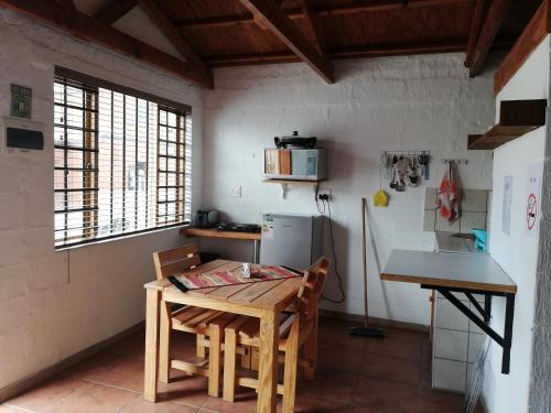 a kitchen with a wooden table and a refrigerator at Walvis Bay Backpackers & Self-catering in Walvis Bay