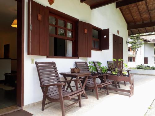 d'une terrasse avec une table et des chaises en bois. dans l'établissement Hotel Fazenda São Moritz, à Teresópolis