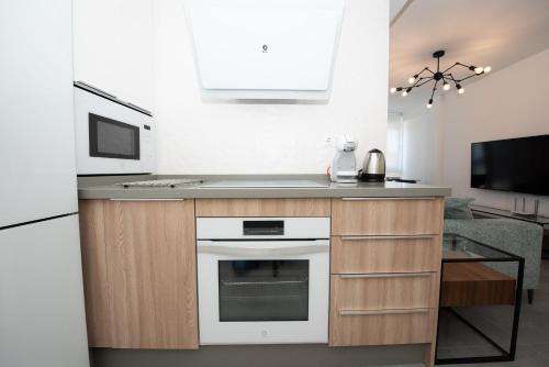a kitchen with a white oven and a microwave at Benigno Premium Center in Málaga
