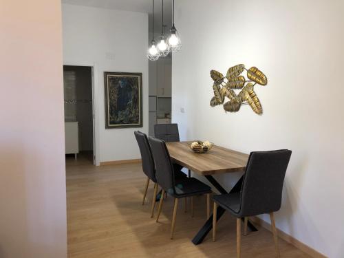 Un comedor con mesa y sillas de madera. en APARTAMENTOs IGLESIA DE SANTIAGO, en Jerez de la Frontera