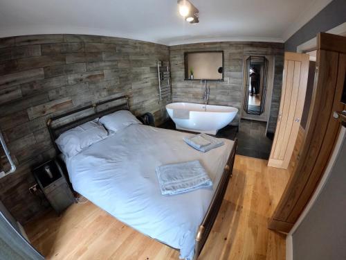 a bedroom with a bed and a tub and a sink at 46 Y Lanfa in Aberystwyth