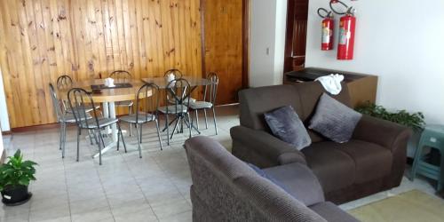 a living room with a couch and a table and chairs at Vista Bela in Campos do Jordão