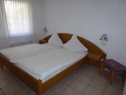 a bed with white sheets and pillows in a room at Ferienwohnung Sewenig in Müden