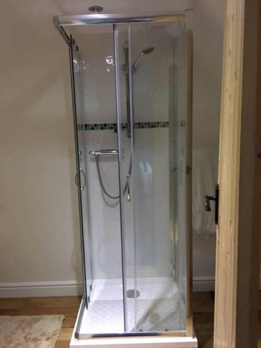 a shower with a glass enclosure in a room at Orchard Cottage in Canterbury