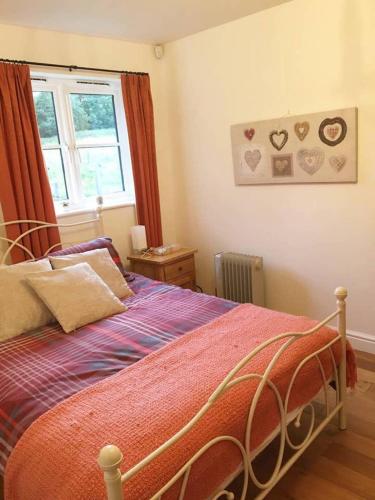 
a bedroom with a bed and a window at Orchard Cottage in Canterbury
