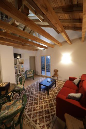 sala de estar con sofá rojo y mesa en Chalet les airelles en Labaroche