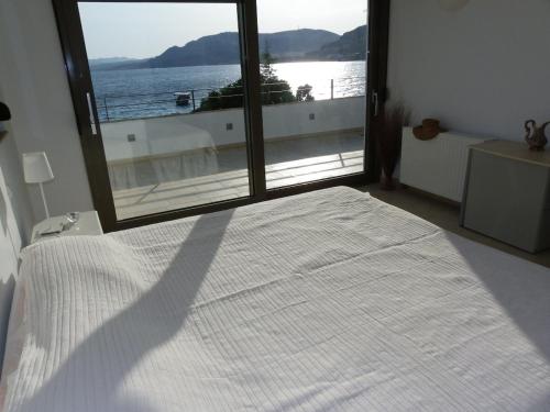 a bedroom with a bed with a view of the ocean at Pefkos Beachfront Villa in Pefki Rhodes