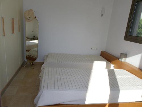two beds in a room with a mirror at Pefkos Beachfront Villa in Pefki Rhodes
