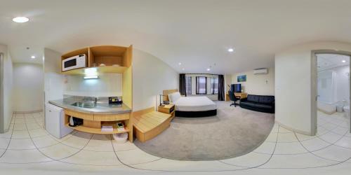 a hotel room with a bedroom and a bed and a kitchen at Edit Auckland Central in Auckland