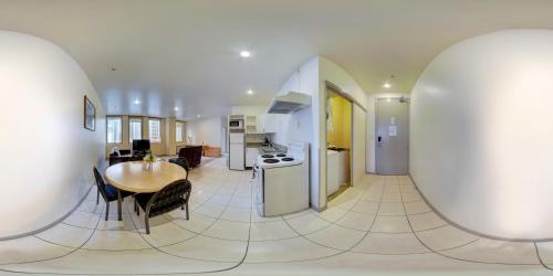 a kitchen and dining room with a table and a kitchen and a living room at Edit Auckland Central in Auckland