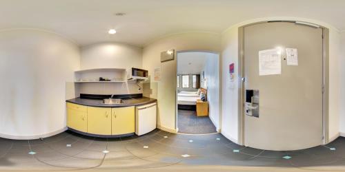 a room with a kitchen and a room with a bed at Edit Auckland Central in Auckland