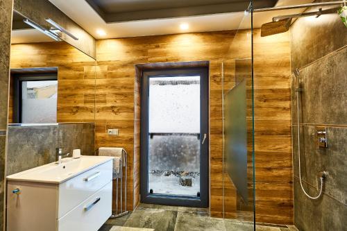 a bathroom with a sink and a glass shower at SCANDIC Apartments Boží Dar in Boží Dar