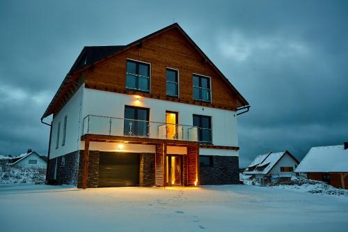 a large house in the snow in the winter at SCANDIC Apartments Boží Dar in Boží Dar