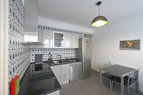 a kitchen with a counter and a table in it at Matriz Guest House in Portel