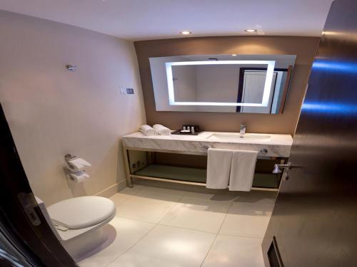 a bathroom with a sink and a toilet and a mirror at Spark Hoteles in Antofagasta