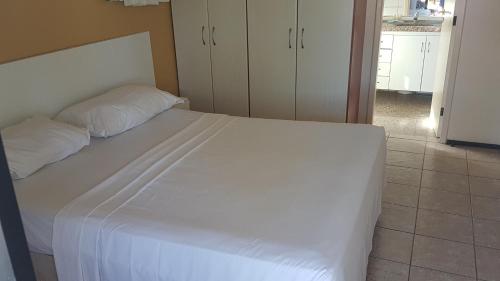 - une chambre avec un grand lit blanc et des oreillers blancs dans l'établissement Aquaville Resort Porto Das Dunas block 63, à Aquiraz